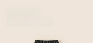 Detail of elastic drawstring waistband and striped fabric on dark gray children pants
