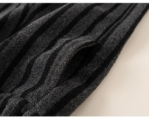 Detailed close-up of thick grey striped knit fabric and side pocket on winter trousers