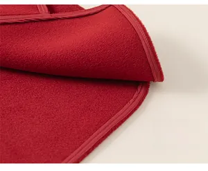 Détail d'un gilet rembourré rouge montrant les coutures et la texture chaude du tissu