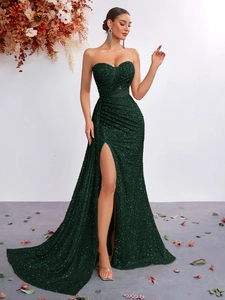 Detail of emerald green sequin fabric and pleated high-slit on luxury evening dress