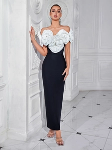 Detail of elegant off-shoulder evening dress with 3D white floral accents and black bodice