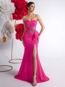 Detail of hot pink strapless dress featuring heavy beadwork and cascading ruffles with high slit