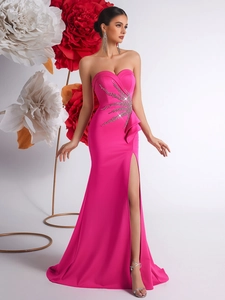 Fuchsia strapless evening gown with ruffles, heavy rhinestones, and side slit detail