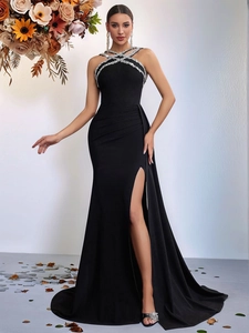 Detail of elegant black fishtail gown featuring a halter neck and silver rhinestone trim