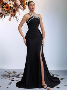 Close-up of halter neck evening gown with rhinestones and elegant side slit detail