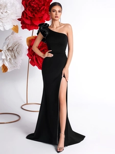 Detail view of one-shoulder evening dress with oversized floral decor and high slit