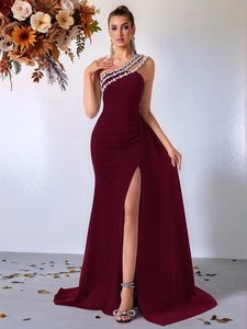 Détail de robe de soirée bordeaux à une épaule avec strass et fente latérale haute