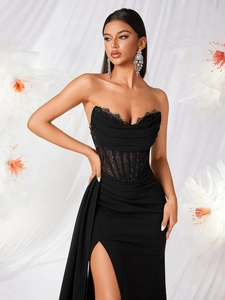 Close-up of black strapless evening dress with lace trim and sequined mesh waist detail