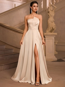 Detail of elegant champagne satin evening dress with asymmetrical folding and high slit