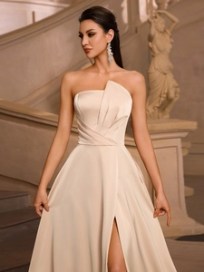 Close-up of champagne satin evening dress with pleated bodice and thigh-high side slit