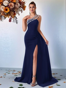 Détail d'une robe de soirée bleu marine à une épaule avec strass et plis à la taille