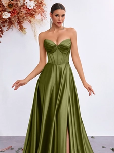 Dettaglio dell'abito in raso verde oliva con corsetto steccato e pieghe in vita eleganti