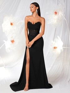 Detail of corset bodice with lace trim and sequined boning on a black evening gown