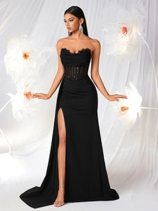 Detailed view of the black lace corset bodice and thigh-high slit on a formal evening gown