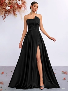Detailed view of elegant black satin strapless evening gown with thigh-high slit and pleats