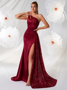 Détail d'une robe de soirée bordeaux à une épaule avec paillettes et fente haute