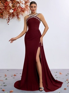 Detail of burgundy halter evening gown with rhinestone neckline and high side slit
