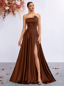 Detailed view of dark brown satin dress featuring pleated tube top and high side slit