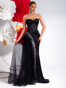 Détail d'une robe de soirée noire bustier avec bordure en strass argentés et satin