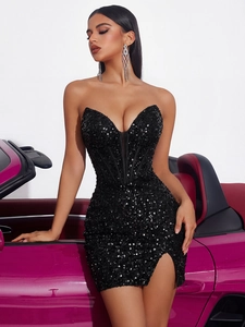 Dettaglio dell'abito nero con paillettes, corpetto strutturato e spacco laterale alla moda