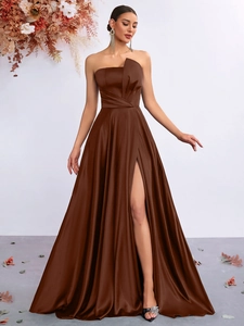 Detail of elegant dark brown satin evening gown with high side slit and slim fit design