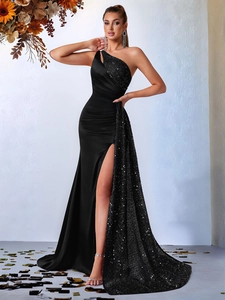Détail de robe de soirée noire à paillettes, épaule dénudée, fente haute et taille drapée