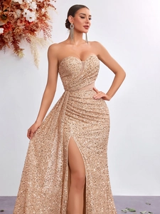 Elegant gold sequin strapless evening gown with a high slit and mermaid silhouette