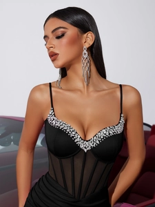 Detail of deep V-neck dress featuring silver rhinestone trim and corset fishbone design