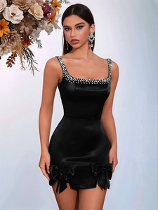 Détails des bretelles en strass et des nœuds sur une robe de soirée en satin noir