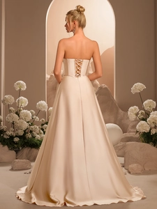 Abito da sera in raso champagne con corsetto stringato sulla schiena e gonna a trapezio