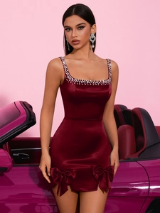 Détails des bretelles en strass et des nœuds en satin sur une robe mini bordeaux
