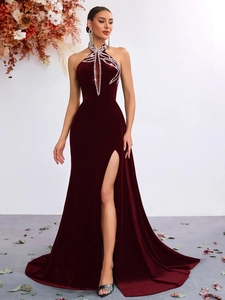 Detail of burgundy velvet dress with sparkling rhinestone starburst neckline and leg slit