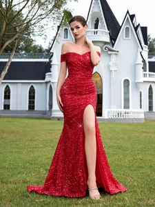 Dettaglio dell'abito da sera rosso con paillettes, scollo a barchetta e spacco alto al castello