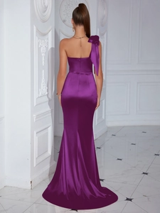 Detail of purple satin evening dress featuring a large shoulder bow and fishtail silhouette