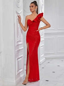 Detail of red sequin dress showing ruffled asymmetric shoulder and sparkling fabric texture