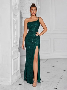 Détail du tissu à paillettes vert émeraude et de la fente haute sur la robe de soirée asymétrique