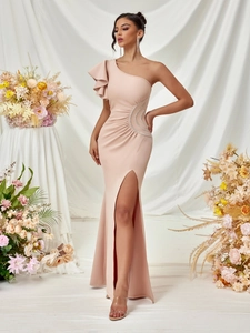 Detail of a one-shoulder pink evening gown with floral accents and a high side slit