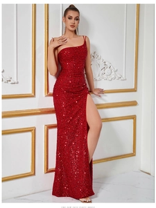 Détail de la robe de soirée rouge à paillettes avec coupe asymétrique et fente haute