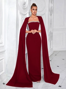 Dettaglio degli strass argentati sulla scollatura a barca di un elegante abito da sera rosso