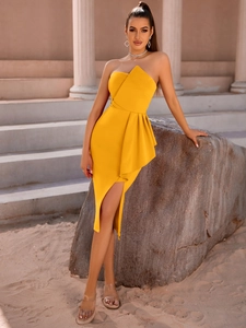 Detail of yellow one-shoulder dress with ruffled waist and asymmetrical slit hem