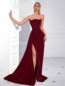 Detail of burgundy satin evening dress showing rhinestone embroidery and high slit