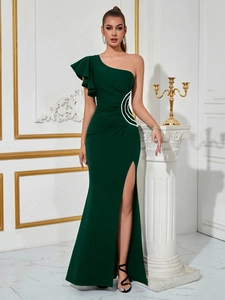 Detail of elegant dark green one-shoulder evening gown with ruffles and side slit