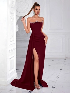 Detail of burgundy tube evening gown featuring sparkling rhinestone trim and elegant draping