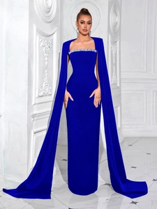 Dettaglio dell'abito da sera blu reale con scollo di strass e maniche a mantella con spacco