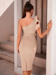 Detail view of the elegant one-shoulder ruffle design and back slit on the apricot dress