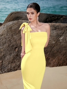 Detail of elegant bright yellow one-shoulder evening dress with a large bow on the shoulder