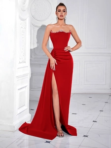 Detail of red tube top evening dress with silver rhinestone trim and high side slit