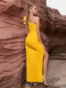 Détail de robe de soirée jaune à épaule dénudée avec volants et fente latérale