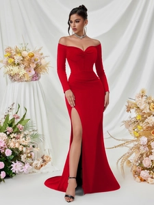 Detail view of the red off-the-shoulder evening gown with corset waist and high slit design