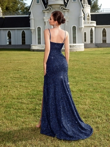 Détail d'une robe de soirée à paillettes bleu marine avec dos nu et fente haute latérale